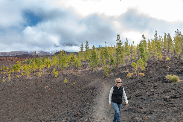 西班牙特内里费，一个成熟的女人在拍摄埃尔·特多火山下的一条道路图片下载