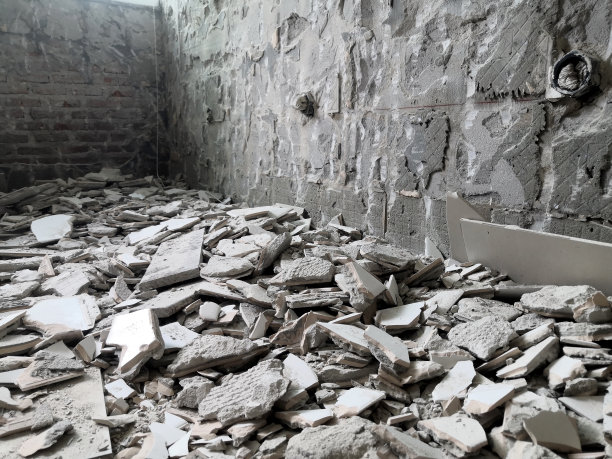 拆除旧瓷砖墙面，为安装新瓷砖做好准备。改造的概念。图片下载