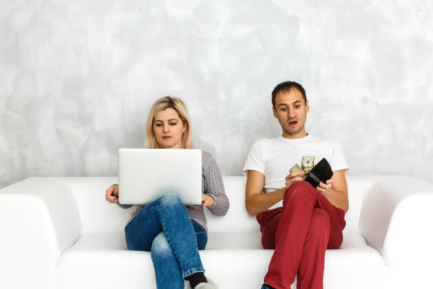 一对年轻夫妇躺在沙发上，在网上购物图片下载