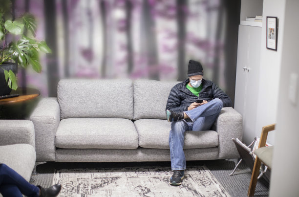 一个年轻的白人男子坐在牙医的候诊室里。图片下载