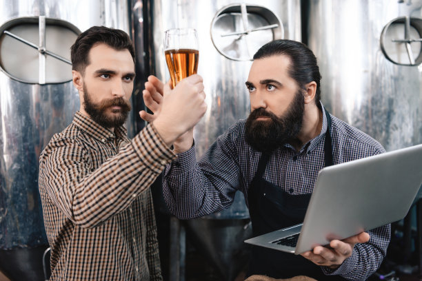 两个酿酒商在啤酒厂检查啤酒的质量。图片下载