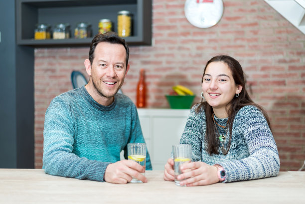 微笑的夫妇在休闲服装餐厅，桌上放着一杯水图片下载