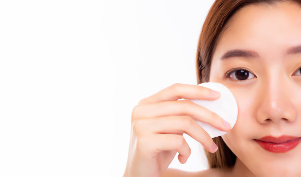 美女洁面，用化妆棉、洁面乳和爽肤水来卸妆。迷人的女孩面部皮肤很好。皮肤护理的概念。白色背景，拷贝空间图片下载