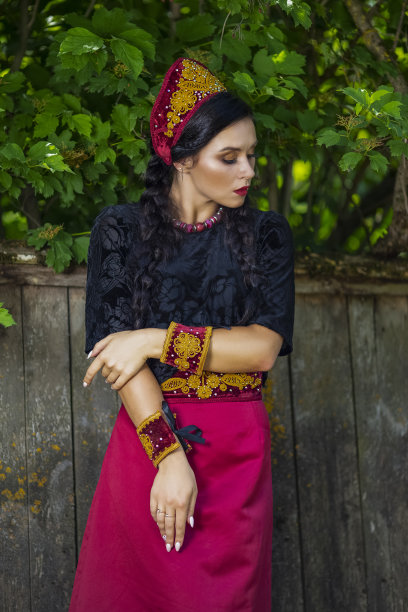 魅力时尚模特在俄罗斯风格装饰Kokoshnik在户外对着旧木栅栏摆姿势。垂直拍摄图片下载