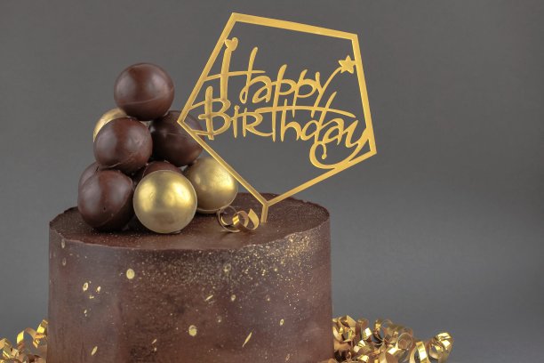 金色装饰的巧克力生日蛋糕。节日，庆祝，时尚，简约的概念。图片下载