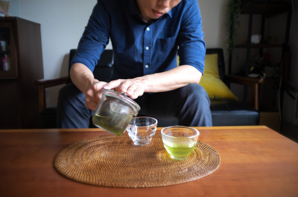 男子在家中客厅冲泡日式茶图片下载