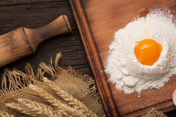 面包烘焙的概念。鸡蛋，面粉，古董木桌上的小穗。图片下载