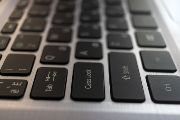 笔记本电脑键盘关闭。金属背景上的黑色英文俄文字母图片下载