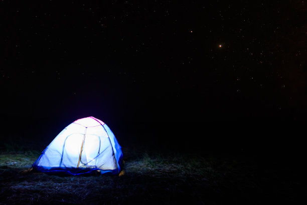 星空下照亮的蓝色帐篷。旅游露营概念图片下载