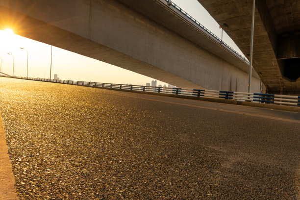 日落时分，现代城市桥下空荡荡的柏油路。图片下载