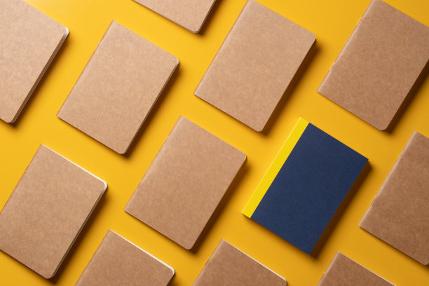 创意内容营销理念。顶部视图的蓝色笔记本对齐在模式上的黄色表背景。为在线广告内容的模型。独特的想法图片下载