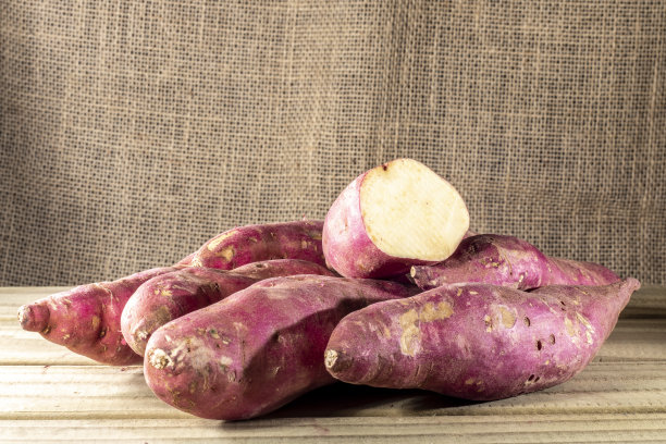 木桌上放着红薯，背景是巴西的黄麻图片下载