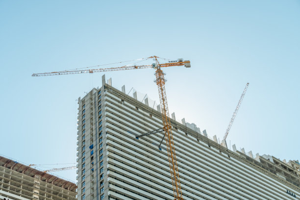 在巴统建造多层建筑。建筑背景上的起重机。一层楼房映衬着蓝天。图片下载