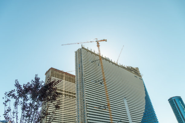 在巴统建造多层建筑。建筑背景上的起重机。一层楼房映衬着蓝天。图片下载