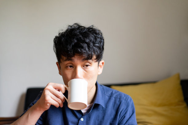 一个男人在客厅里喝咖啡图片下载