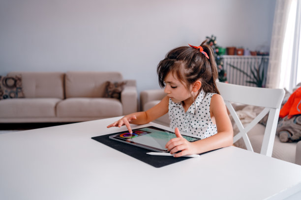 聪明的青春期前女学生在家用平板电脑做家庭作业。使用小工具学习的孩子图片下载