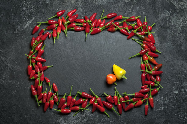 红辣椒矩形框架上的黑色桌子和黑色岩石切割桌，俯视图和复制空间为您的烹饪文本。图片下载