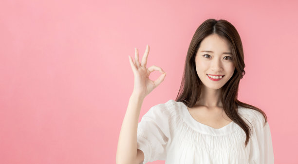年轻的亚洲妇女显示一个OK的手势。图片下载