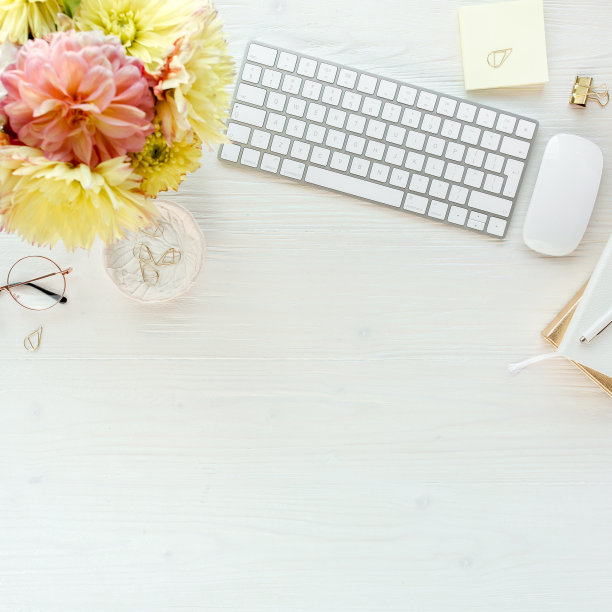 平放的女性办公桌。女性的工作空间有电脑，粉红色和黄色的玫瑰花，配件，日记，眼镜在白色的背景。俯视图图片下载