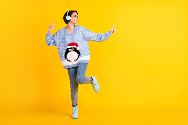 迷人的疯狂女士的全身照片青年派对新年迪斯科舞厅听很酷的耳机舞池夜总会穿丑陋的装饰毛衣牛仔裤鞋子孤立的黄色背景图片下载