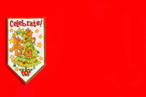 圣诞背景以红色绣新年旗为背景，有节日、新年和圣诞节的概念。假期。圣诞树上的猫，一张有趣的节日照片图片下载