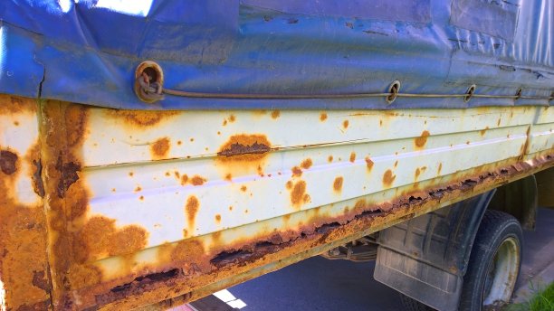 旧卡车车身金属薄板腐蚀。生锈的混乱的表面。被路面盐破坏的垃圾纹理。生锈的背景。冬季保护、自动涂装。涂上的油漆。汽车车身。卡车。服务。图片下载