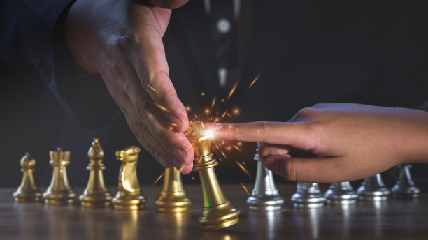 商人之手以火花之光抵挡金王棋落在对手的攻击。业务伙伴或协作。经营理念与竞争理念、战略理念相结合。图片下载