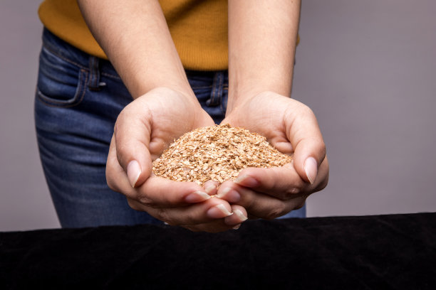 女人拿着不同的种子在黑色的背景图片下载