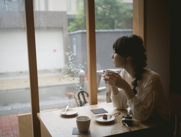 一个梳着辫子的女人在咖啡馆里图片下载