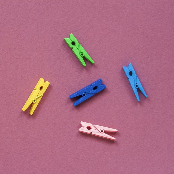明亮的彩色木衣夹在彩色背景上，俯视图，平躺图片下载