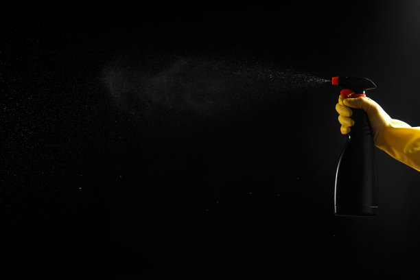 家用清洁剂，手上有黑色喷雾，戴着黄色橡胶手套图片下载