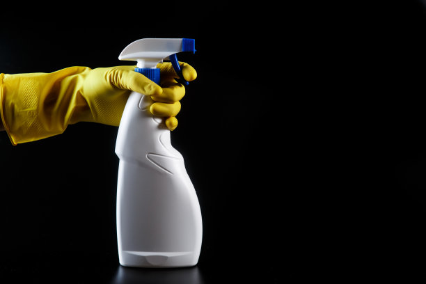 家用清洁剂，手上有白色喷雾，戴着黄色橡胶手套图片下载