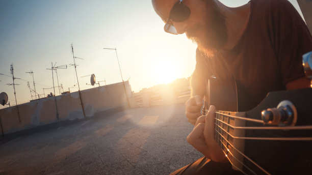 新冠肺炎封锁期间，一名男子在阳台上弹吉他图片下载