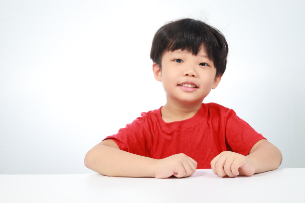 男孩坐在桌前，白色背景图片下载