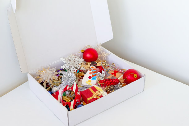 圣诞装饰品在盒子里。白色背景上有圣诞装饰的盒子。图片下载
