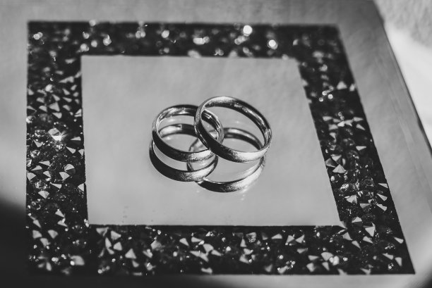 玻璃盒子上放着新郎和新娘的结婚戒指。参与。关闭了。前视图。黑白照片。图片下载