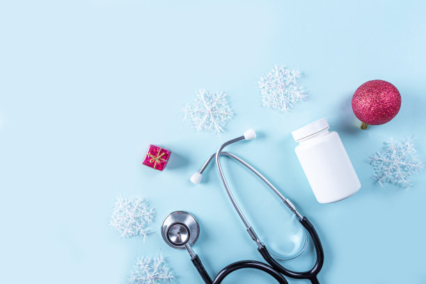 平躺医疗新年组成与听诊器，药丸，礼盒和圣诞装饰在蓝色的背景。医疗保健理念为卡片、日历、封面。文本复制空间图片下载