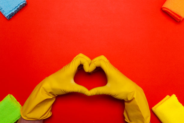 中间是双手戴着橙色橡胶手套，红色背景上画着一颗心图片下载