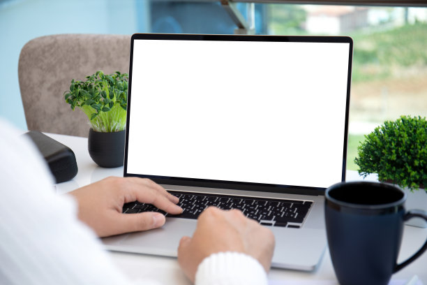 在办公室里，男性的手放在笔记本电脑的键盘上，屏幕是隔离的图片下载