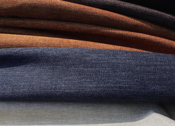 在面料市场上发现的不同颜色的布料和织物样品的详细近距离查看图片下载