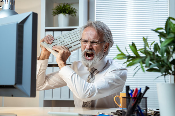 商人歇斯底里地对着电脑大喊大叫，手里拿着键盘图片下载
