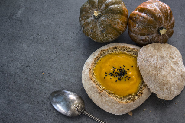 灰色餐桌上的面包碗自制南瓜汤顶视图照片图片下载