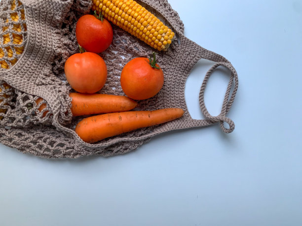 新鲜水果，西红柿，胡萝卜，玉米棒，棕色网眼袋，白色背景。从上面的照片。“零浪费”。生态。爱护环境。适当的营养,素食主义图片下载