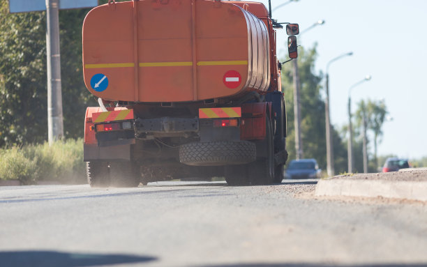 大橘色工业卡车在路上行驶图片下载
