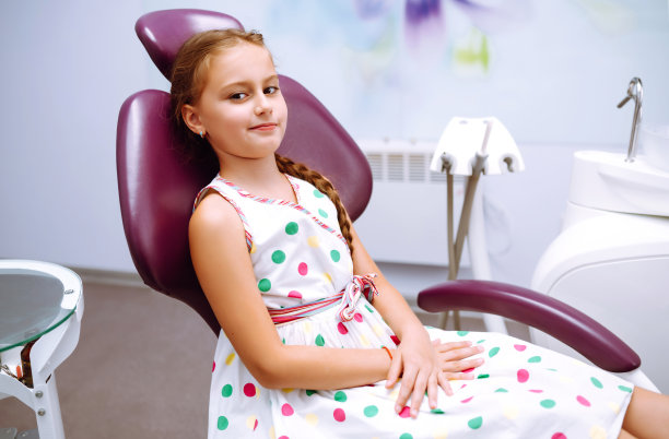 小女孩看牙医。牙医办公室里坐着个美女。图片下载