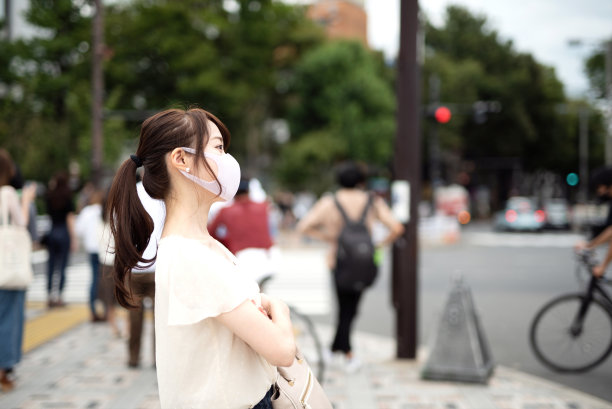 一个戴面具的女人站在街上图片下载