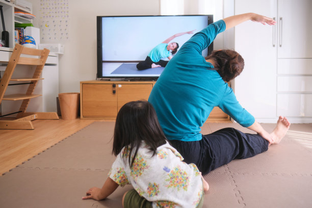 妇女运动与看电视的孩子图片下载