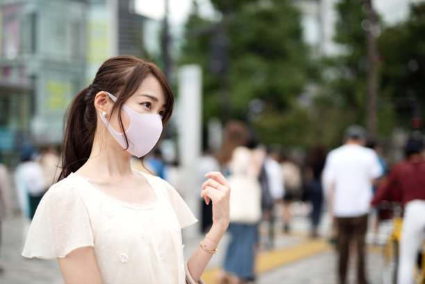 一个戴面具的女人站在街上图片下载