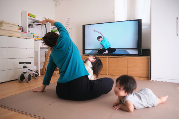 妇女运动与孩子和婴儿看电视图片下载