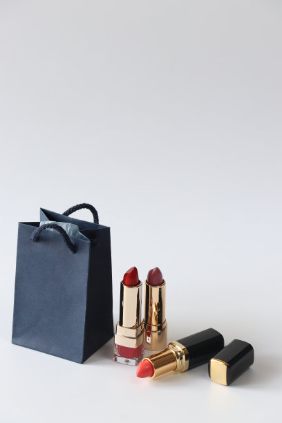 背景是口红和一个蓝色的购物袋。节日的概念。孤立。图片下载